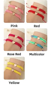 Detailed view of handmade braided bracelets in five colors with golden heart charms