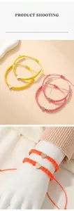 Detailed view of colorful woven heart bracelets in yellow pink and orange tones