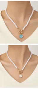 Detail of white pearl choker with sunflower charm and OT toggle clasp on model neck