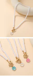 Detail of sunflower charm pearl bracelet with golden toggle clasp and colorful enamel