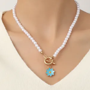 Bohemian pearl bracelet with daisy charm and golden toggle clasp on model wrist