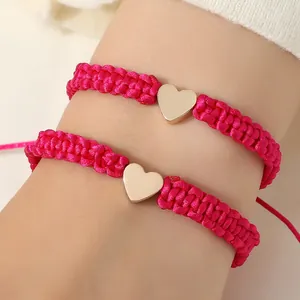 Adjustable rainbow heart woven bracelet set with golden charm on wrist for women