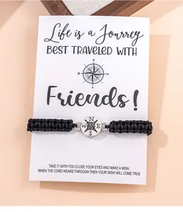 Detail van gevlochten kompas vriendschapsarmband op een witte geschenkkaart