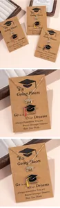 Macro detail of gold graduation cap necklace with crystal inlay and enamel on quote card
