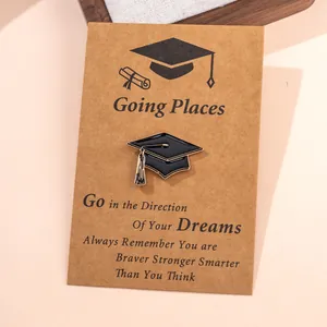 Afstudeer enamel pin op kraftkaart met kompas-thema en motiverende tekst op kaart