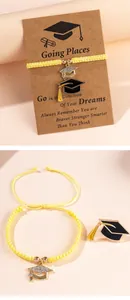 Detail of graduation bracelet set with gold doctoral cap charm and black enamel tassel pin