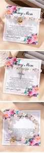 Detailed view of elastic pearl bracelets with heart charms on floral gift cards for mom