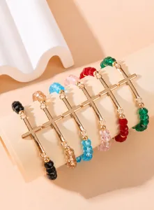 Detail of colorful faceted crystal beaded bracelets with golden cross pendants