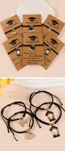 Detail of hand-woven graduation bracelets with mortarboard charms and inspirational card