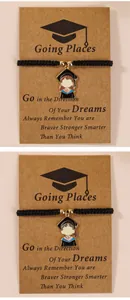 Detail of hand-woven graduation bracelets with cartoon academic cap charms on cards