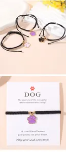 Détail du bracelet tressé ajustable avec breloque patte de chien colorée et billes d'or