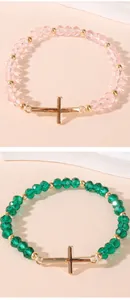 Close-up of faceted crystal beads bracelet with a polished gold stainless steel cross charm