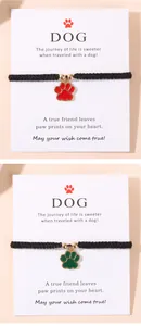 Détail de pendentifs patte de chien tissés main en rouge et vert sur cartes cadeaux