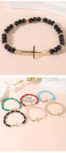 Detail view of colorful beaded stretch bracelets with golden cross charms and size info
