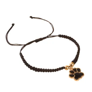 Bracelet tressé noir réglable avec pendentif patte dorée et détails en émail