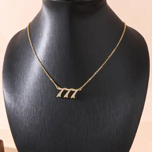 Exquisite gold 777 angel number necklace with pavé crystals on black mannequin