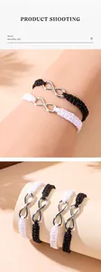 Détail de bracelets tressés avec symbole infini réglable en noir et blanc pour couples