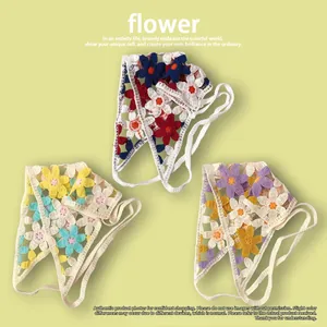 Détail de trois bandeaux triangulaires en crochet fait main avec des motifs floraux