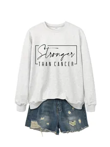 Detail of Stronger Than Cancer print on white sweatshirt with frayed denim shorts
