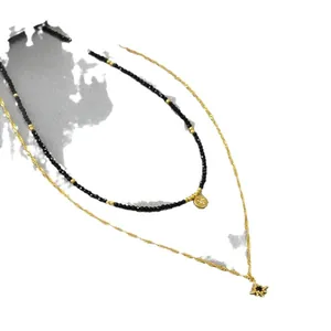 Double-layered gold chain necklace with black spinel beads and star charm pendant