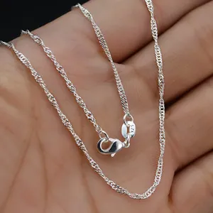 Macro shot of a 925 sterling silver twisted water wave chain with a secure lobster clasp