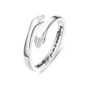 Macro detail of engraved inspirational message on silver adjustable hug ring band