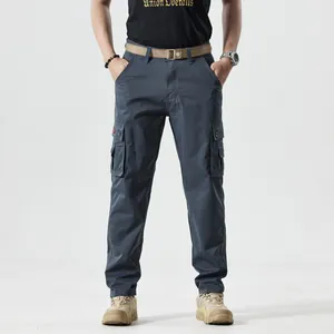 Detail of men's dark blue cargo pants with side pockets and a woven brown belt