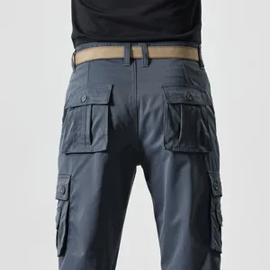 Detail view of cargo pants featuring back button-flap pockets and a woven nylon belt