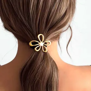 Close-up of golden flower hair tie with pearl center worn on ponytail