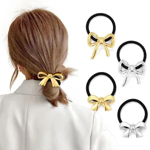 Close-up of golden and silver metallic bow hair ties with high-elasticity black bands