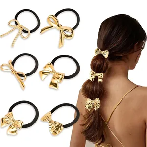 Detail of six golden bow elastic hair ties with smooth and pleated metal finishes