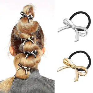 Detail of high-elasticity hair ties featuring gold and silver metallic bow charms for women