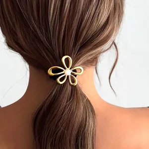 Golden flower hair tie with pink bead on high elastic band shown on brown hair