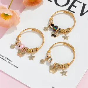 Detailed shot of golden cable charm bracelets with butterfly and star pendants
