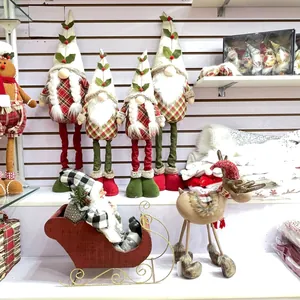Détail de gnomes de Noël en peluche avec chapeaux à carreaux et décor de traîneau