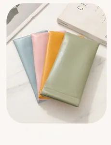 Detail view of four colorful PU leather sunglasses pouches on white marble background