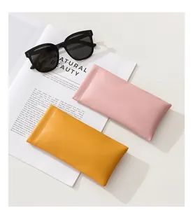 Detailed view of pink and yellow PU leather squeeze glasses pouches with stitching