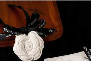 Detailed macro view of a white camellia plaster diffuser stone with black ribbon