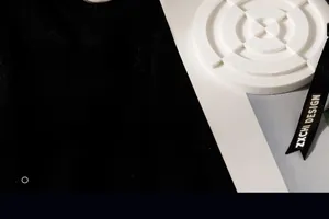 Detailed view of round white plaster diffuser with minimalist texture and black ribbon