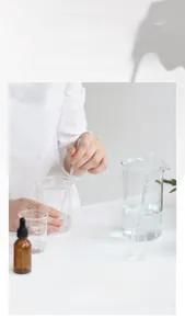 Laboratory setup for perfume making with glass beakers and essential oil dropper bottle