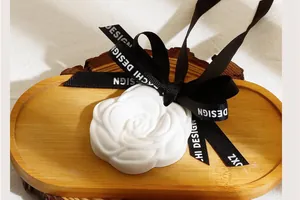 Macro shot of a white rose-shaped plaster diffuser stone with a decorative black ribbon
