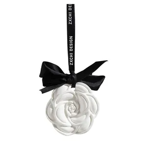 Elegant camellia scented plaster air freshener with black velvet bow and hanging strap