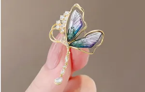 Macro shot of butterfly brooch with purple-green gradient wings and white zircon stones