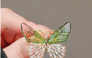Detailed view of an emerald butterfly brooch with glittering wings and cubic zirconia