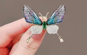 Detailed macro view of an emerald butterfly brooch with green gemstone and purple wings