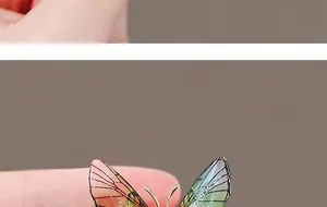 Close-up of emerald butterfly brooch wings with orange gradient and delicate mesh texture