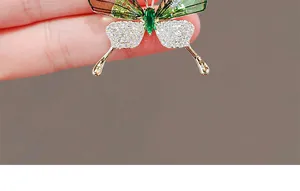 Macro shot of butterfly brooch featuring emerald green stone and sparkling white zircons