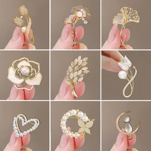 Golden brooch set with emerald zircon and pearls in butterfly and flower shapes