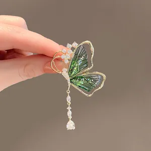 Elegant emerald butterfly brooch with gold metal frame and teardrop pearl pendant