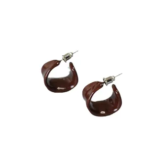 Deep burgundy C-shaped enamel hoop earrings with a glossy finish and vintage aesthetic